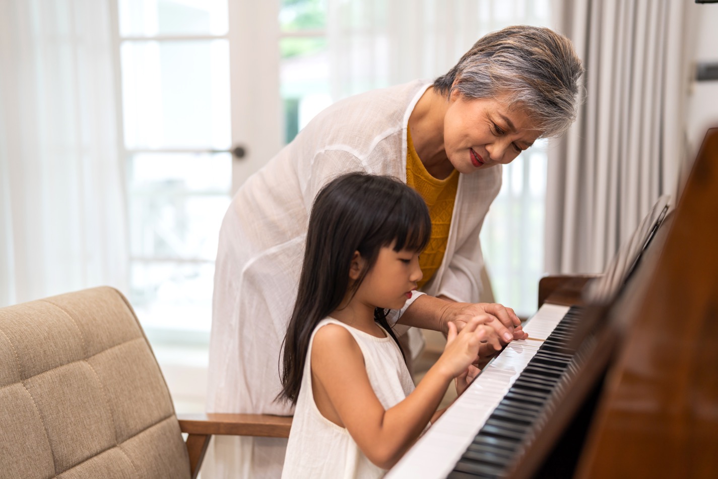 Jeune fille et sa grand-mère jouent du piano